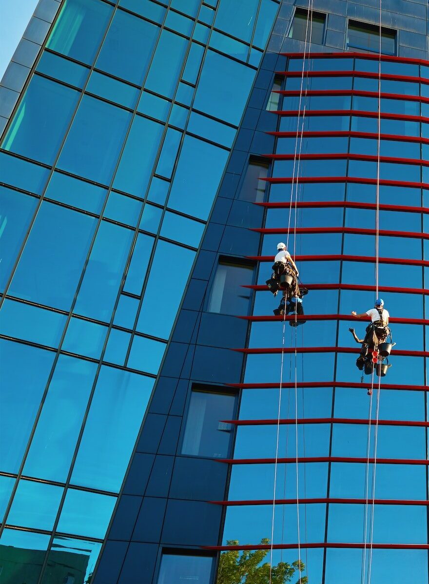 Workers cleaning windows in business center in scyscraper